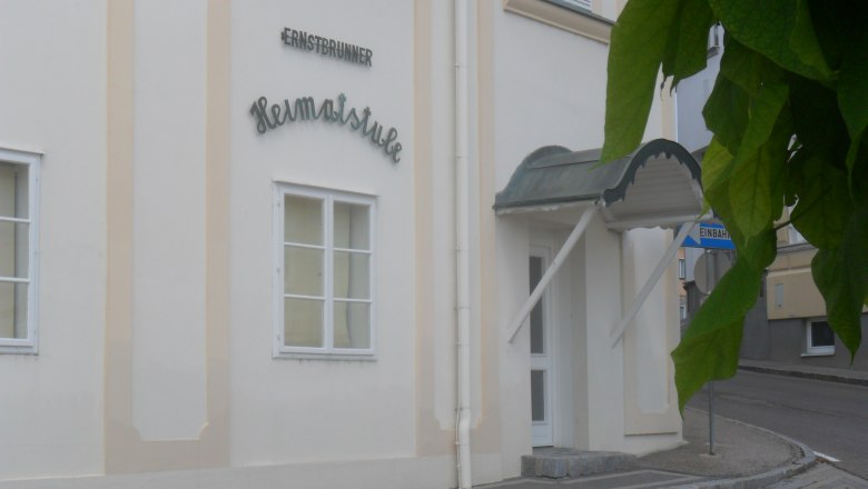 Heimatmuseum Ernstbrunn, © Weinviertel Tourismus Eingang zur Ernstbrunner Heimatstube mit Vordach und Straßenschild.