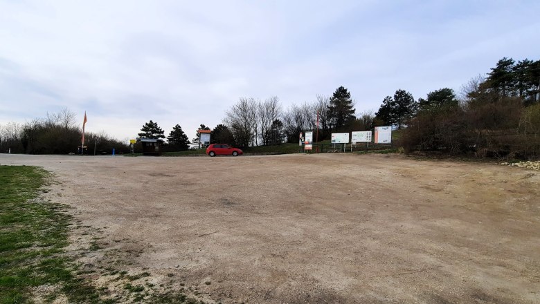 Motorhome parking space, © Bernhard Zechner Empty camper van site with a red car and trees in the background.