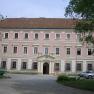 Minoritenkloster, © Gemeinde Asparn Fassade eines historischen Gebäudes mit rosa Putz und weißen Fensterrahmen.