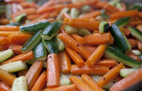 Nahaufnahme von gebratenen Karotten und Zucchini.