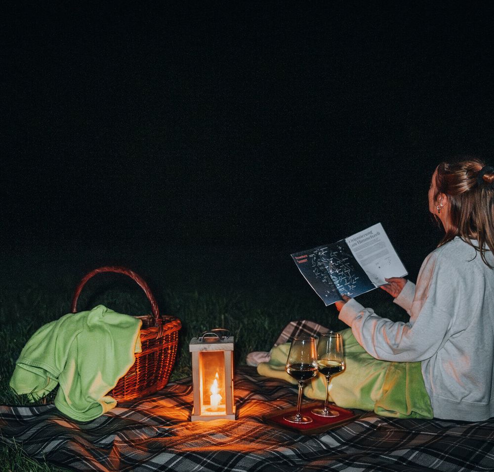 Unter dem funkelnden Sternenhimmel genießen Sie eine romantische Auszeit. Eine Decke, ein Korb voller Leckereien und ein Glas Wein laden zum Verweilen ein. Lassen Sie sich von der Magie der Nacht verzaubern und beobachten Sie die Sterne, die über Ihnen strahlen.