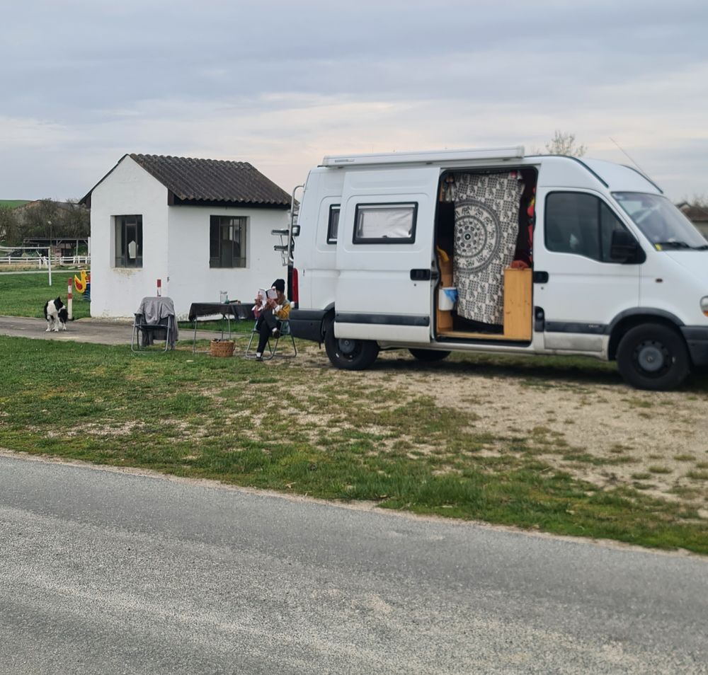 Campingbus vor Spielplatz auf Schotteruntergrund