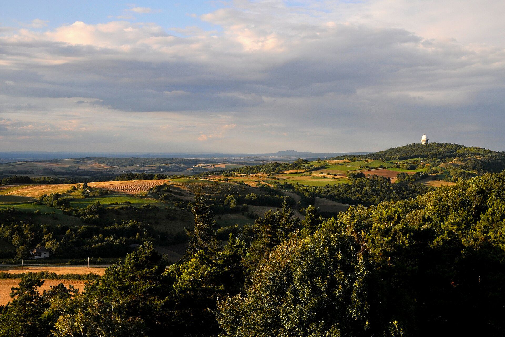 Die sanften Hügel und weiten Felder laden zu einem unvergesslichen Sommerausflug ein. Die goldenen Strahlen der Sonne tauchen die Landschaft in ein warmes Licht und schaffen eine harmonische Atmosphäre, die zum Verweilen einlädt.