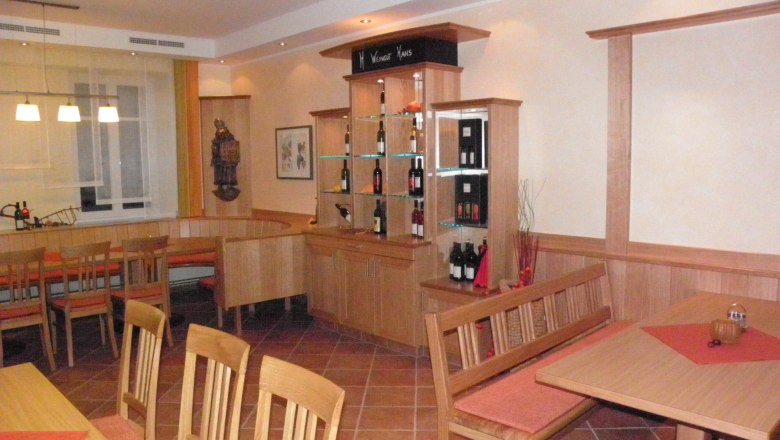Interior view of a cozy dining room with wooden furniture and wine rack.