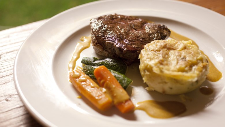 A plate of steak, vegetables and potato gratin.