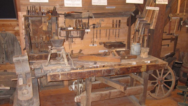 Old carpentry tools on display in a museum.