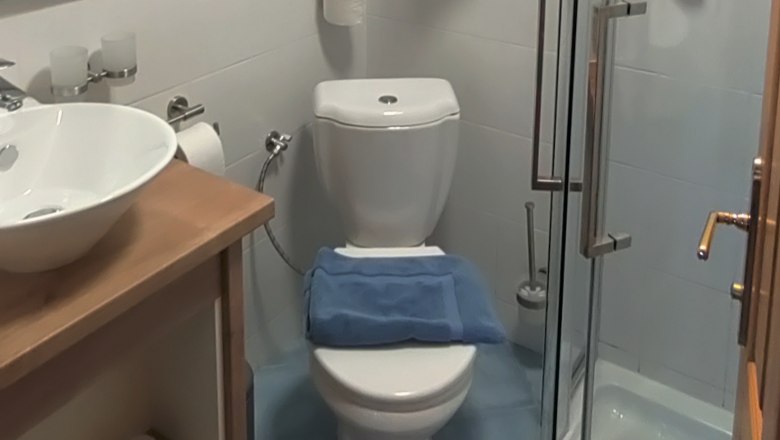 Kleines Badezimmer mit Dusche, WC und Waschbecken.