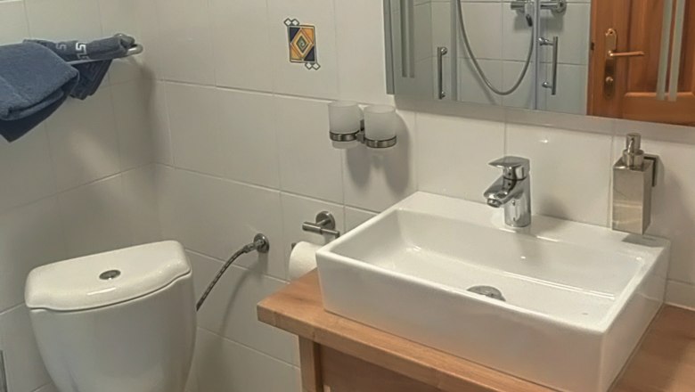 Kleines Badezimmer mit Toilette, Waschbecken und Spiegel.