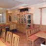 Interior view of a cozy dining room with wooden furniture and wine rack.