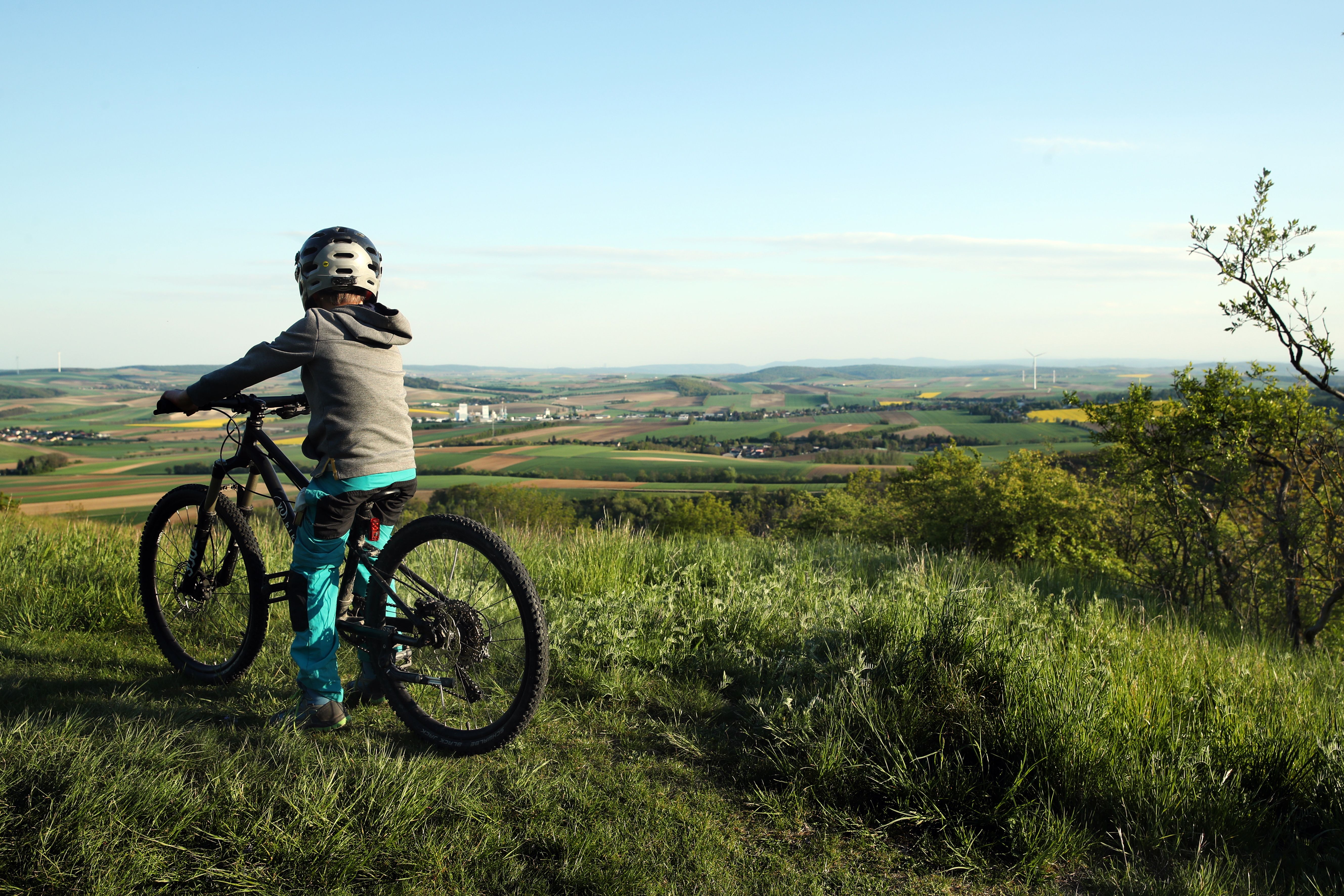Bub mit Mountainbike genießt die Aussicht am Oberleiser Berg im Naturpark Leiser Berge.