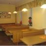 Interior view of a restaurant with wooden tables and benches.